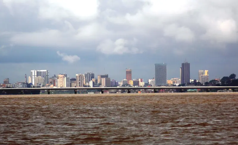 Silhouette du pont Henri-Konan-Bédié enjambant la lagune Ébrié, avec le quartier du Plateau en arrière-plan, à Abidjan.